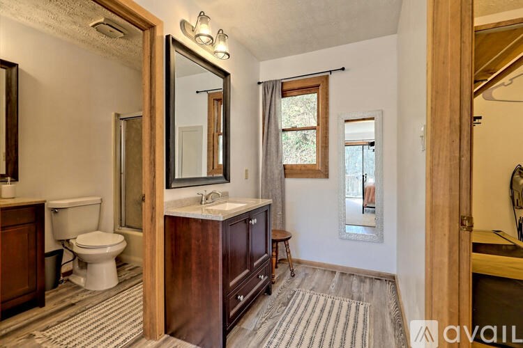 A bathroom with a toilet, sink, and mirror.