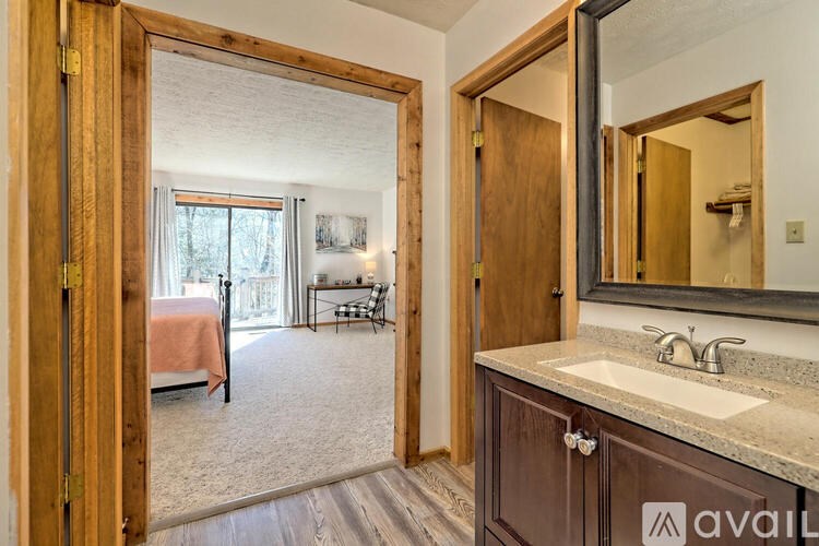 A bathroom with a sink, mirror, and wooden door.