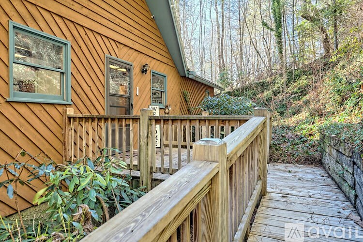 A wooden deck with a railing and a house in the background.