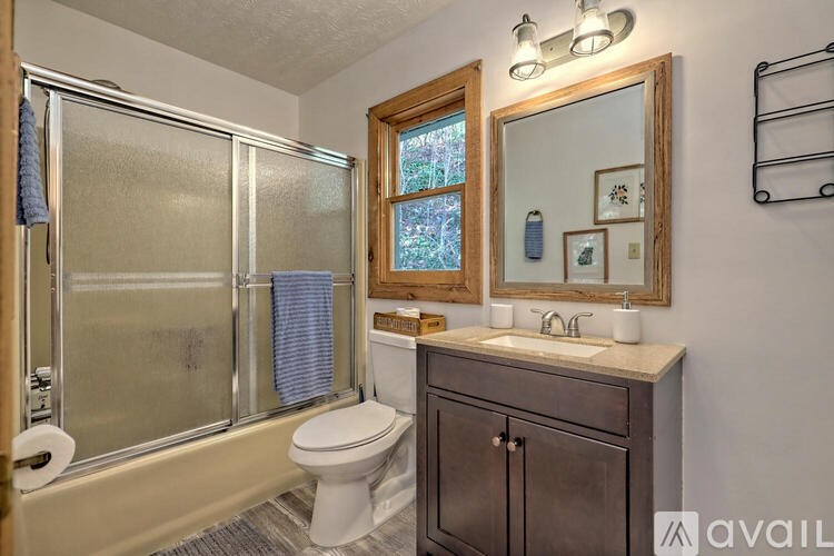 A bathroom with a toilet, sink, and a mirror.