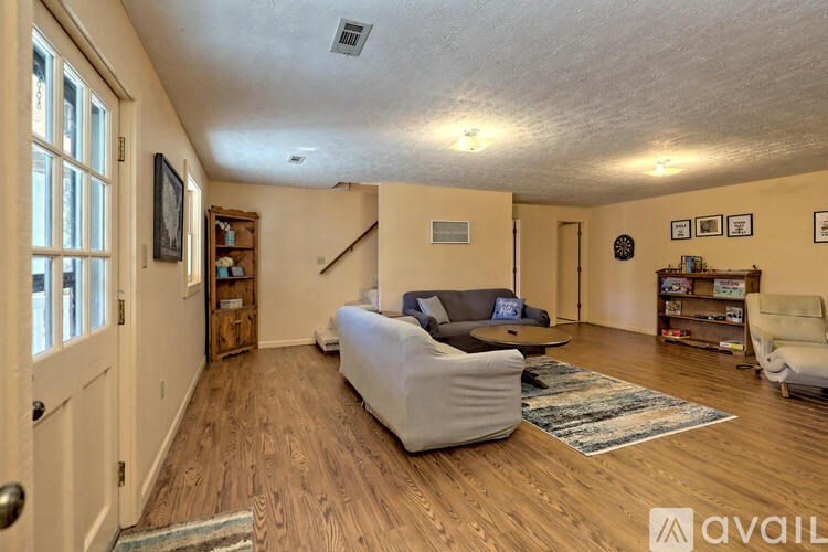 A living room with a couch, chair, and bookshelf.