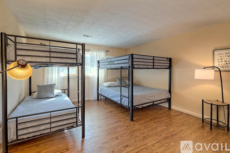 A room with two bunk beds and a small table.