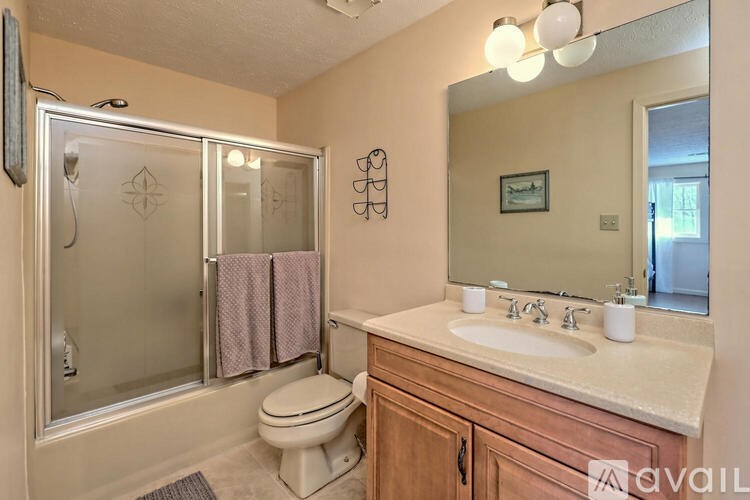 A bathroom with a toilet, sink, and shower.