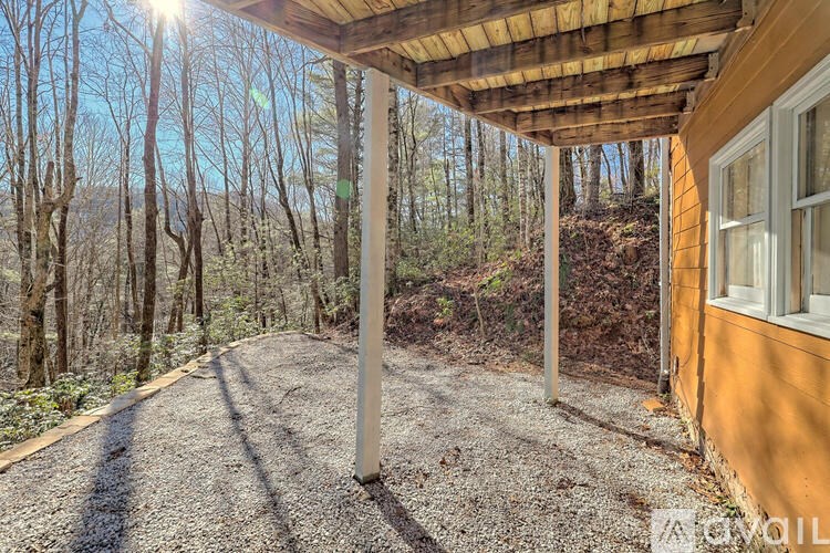 A sunny day with a view of a wooded area from a covered porch.