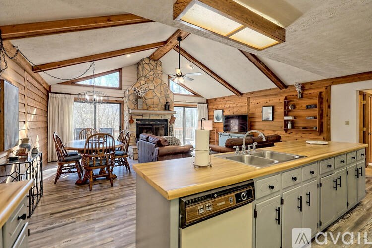 A kitchen with wooden cabinets and a stone fireplace.