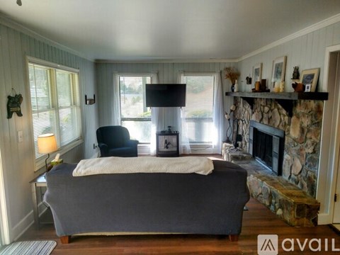 A bedroom with a large bed and a stone fireplace.