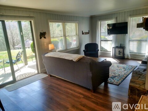 A bedroom with a bed, chair, and sliding glass doors.