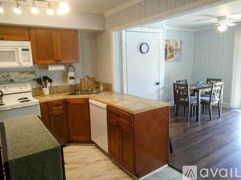 A kitchen with wooden cabinets and a white stove top oven.