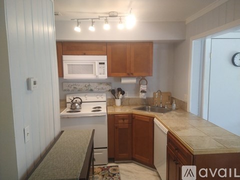 A kitchen with wooden cabinets and a white stove top oven.
