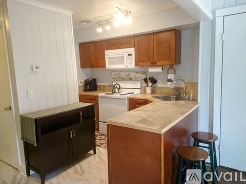 A kitchen with wooden cabinets and a white fridge.