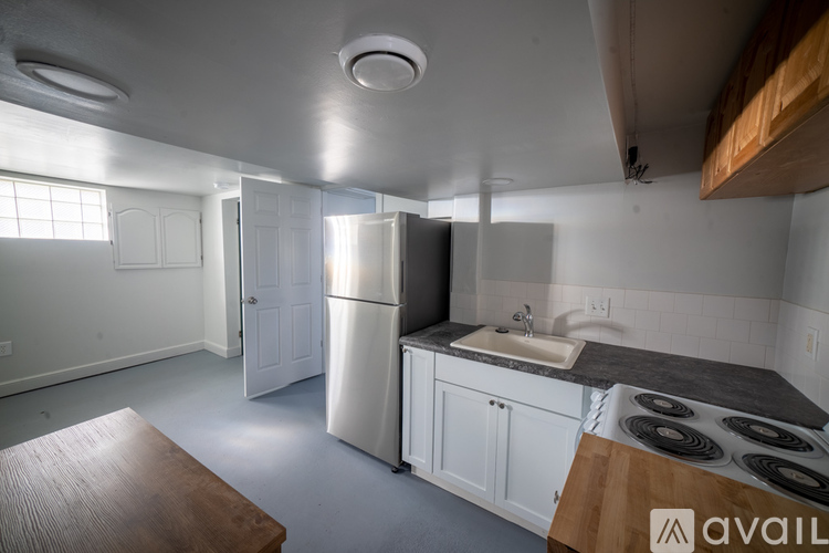 A kitchen with a stove top oven and a refrigerator.