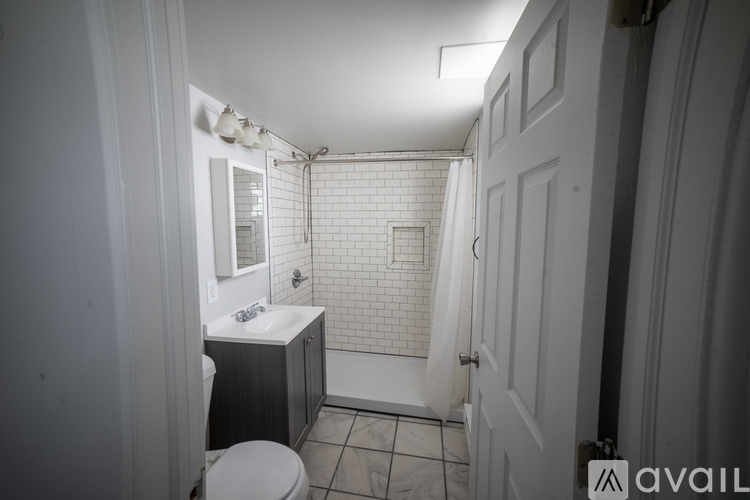 A bathroom with a toilet, sink, and shower.