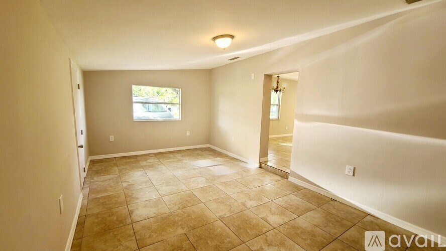 A room with beige tiled flooring and a window.