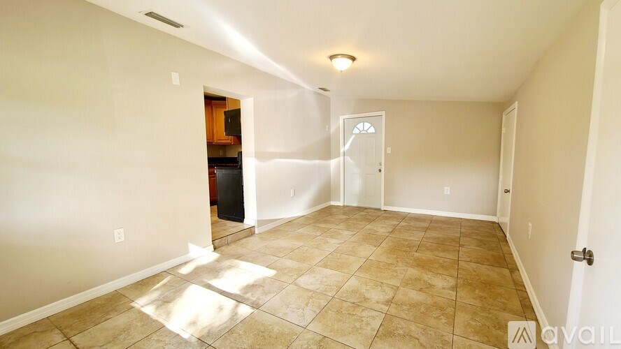 A room with beige walls and tiled flooring is available for rent.