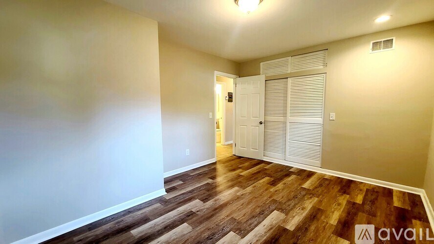 A room with wooden flooring and a white door.