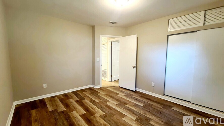 A room with wooden flooring and a white door.