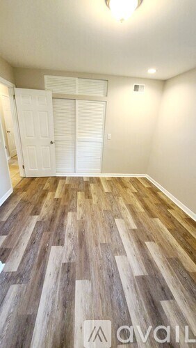 A room with wooden flooring and a white door.