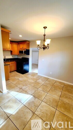 A kitchen with a black counter top and wooden cabinets.