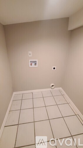 A bathroom with a tiled floor and a toilet paper holder on the wall.