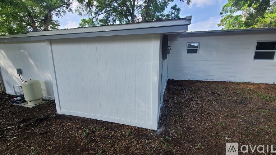 A white garage door is open, revealing a dark interior.