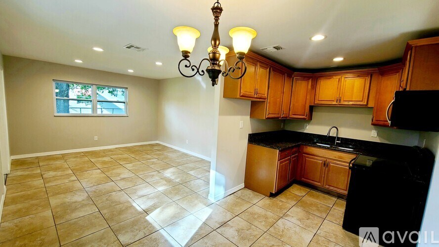 A kitchen with wooden cabinets and a black countertop.