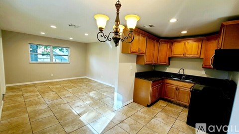 A kitchen with wooden cabinets and a black countertop.