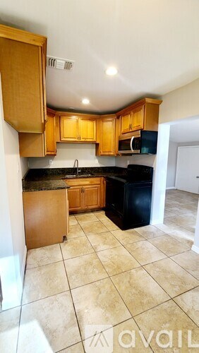 A kitchen with wooden cabinets and black appliances.