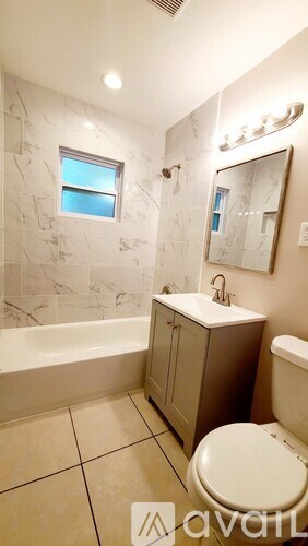 A bathroom with a tub, toilet and sink.