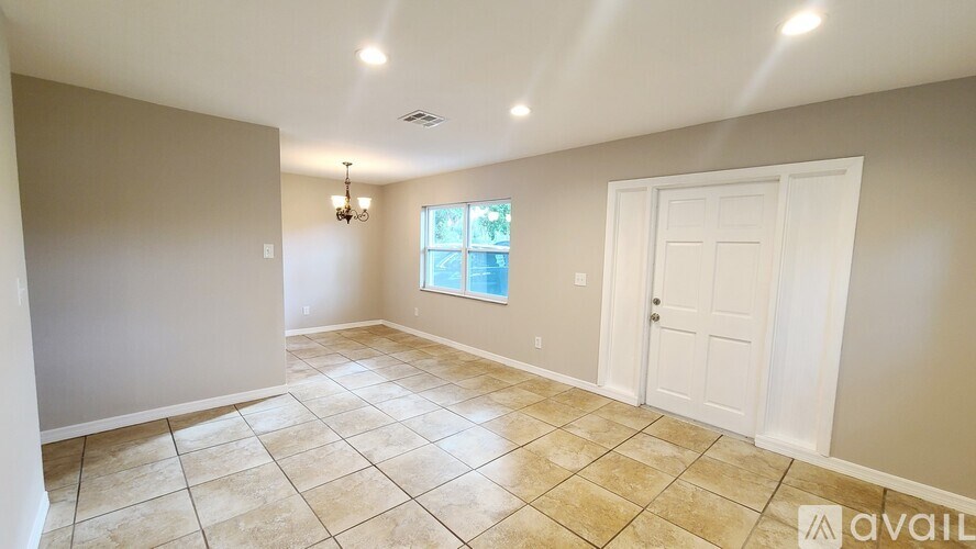 A room with a tiled floor and a window with a view of trees.
