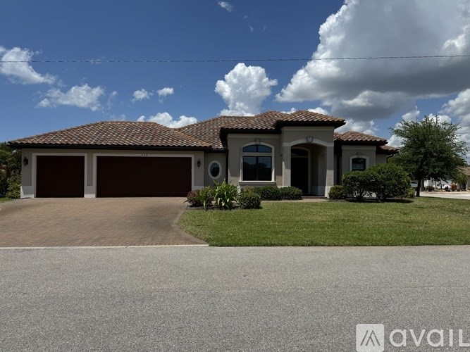 A house with a brown roof and a driveway in front.