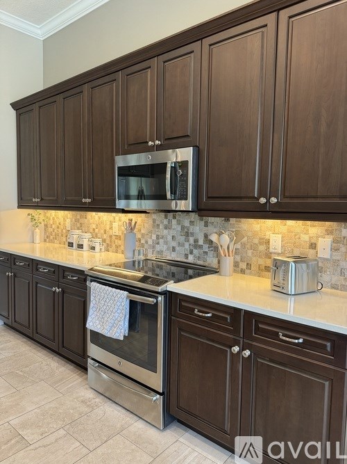 A kitchen with brown cabinets and a stainless steel oven.