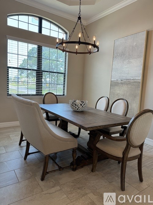 A dining room with a table and chairs.