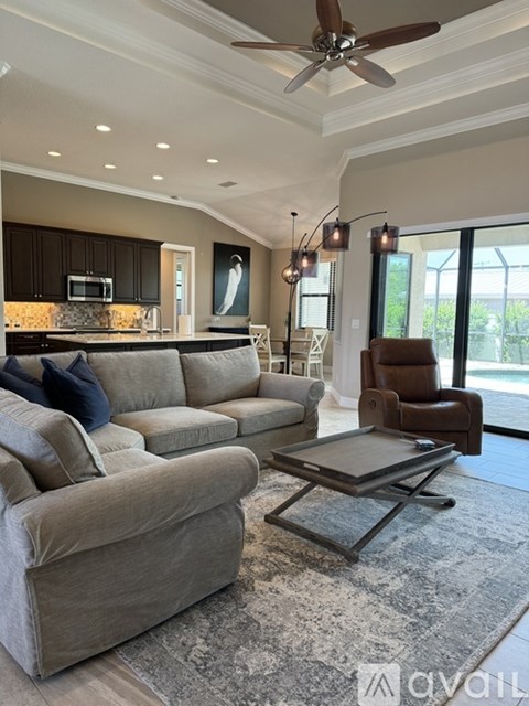 A modern living room with a grey sofa and a brown leather chair.
