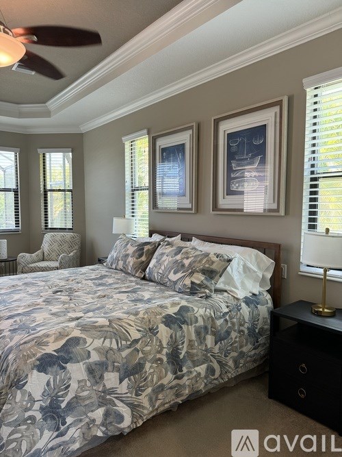 A bedroom with a large bed and a ceiling fan.