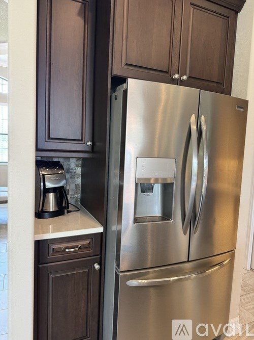 A stainless steel refrigerator with a water and ice dispenser in the middle of the door.