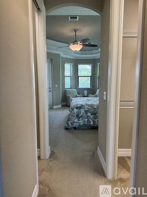 A bedroom with a bed and a ceiling fan.