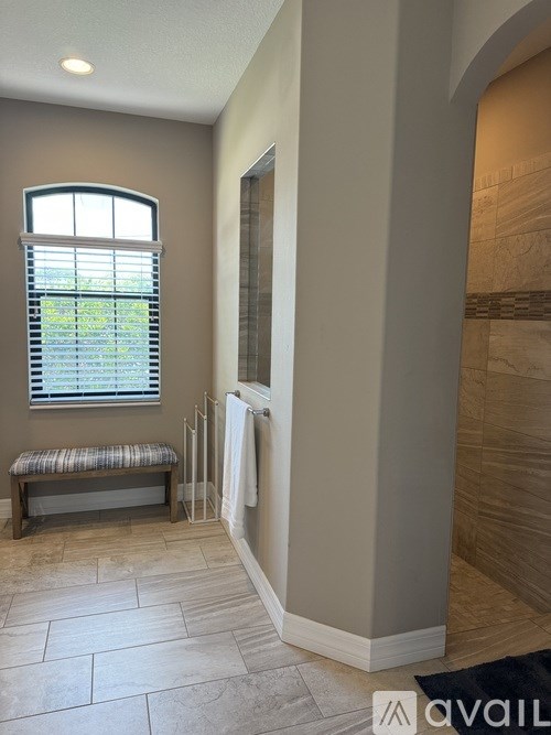 A bathroom with a bench and a window.