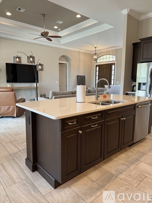 A modern kitchen with dark wood cabinets and a white countertop.