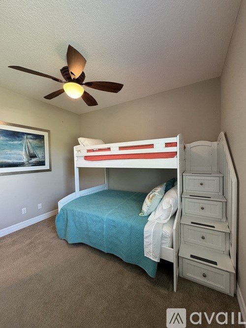 A bedroom with a bunk bed and a ceiling fan.