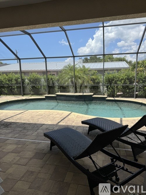 A patio with a pool and a bench.