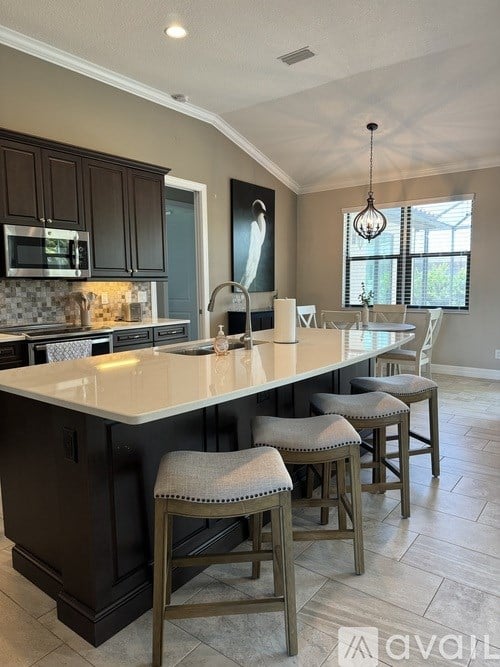 A kitchen with a bar stool in front of the island.