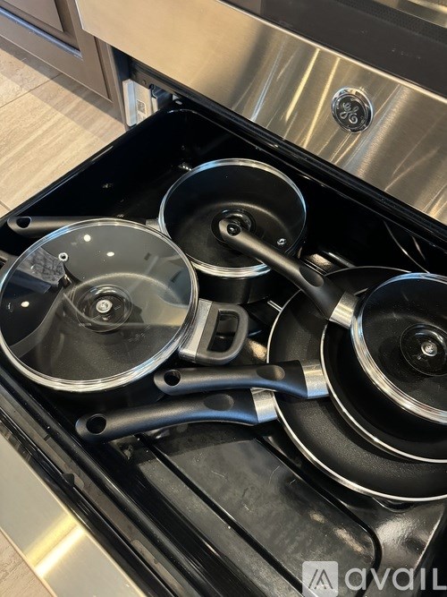 A set of pots and pans are on a stove top.