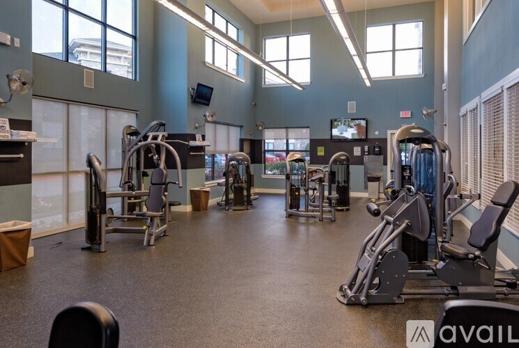 A gym with a variety of equipment including treadmills, weights, and exercise machines.