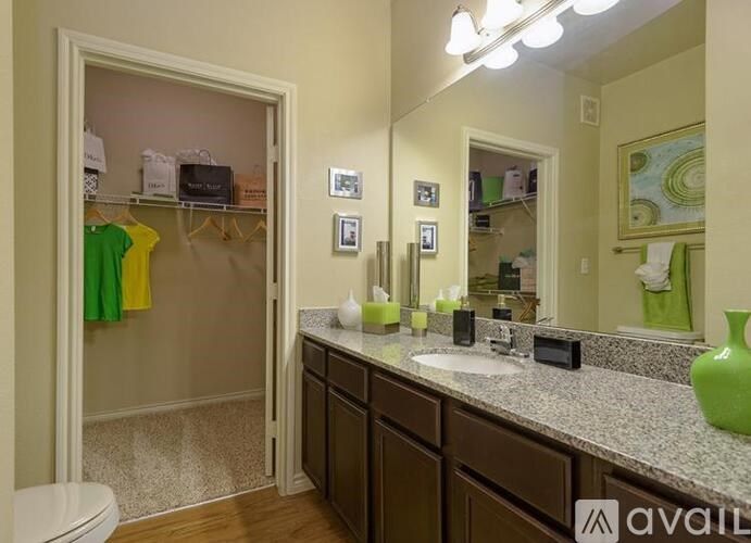 A bathroom with a toilet, sink, mirror, and a shower.