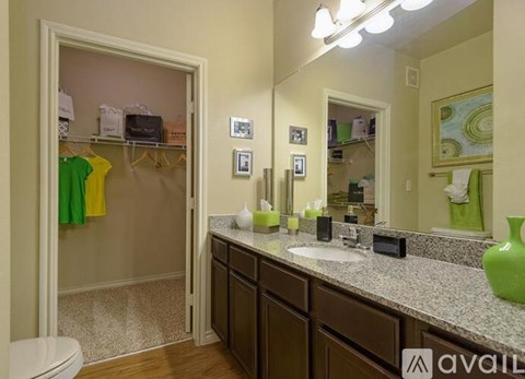 A bathroom with a toilet, sink, mirror, and a shower.
