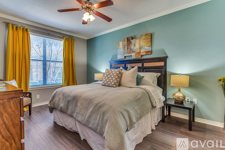 A bedroom with a bed, nightstand, and a ceiling fan.