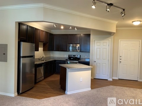 A kitchen with dark brown cabinets and a stainless steel refrigerator.