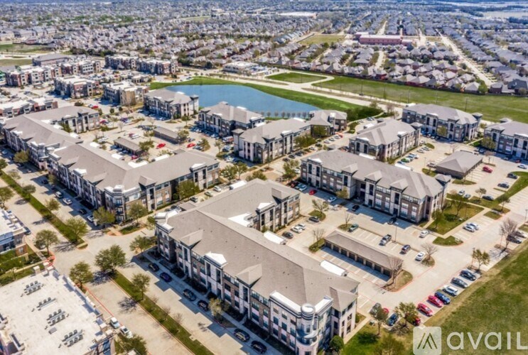 An aerial view of apartment buildings with a lake in the middle.