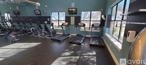 A gym with treadmills, exercise bikes, and other equipment.