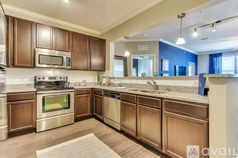 A kitchen with brown cabinets and stainless steel appliances.